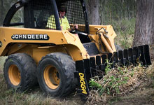 Skid steer loader with a Root Rake.